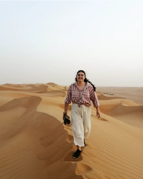 Léa qui marche sur une dune dans un désert de sable