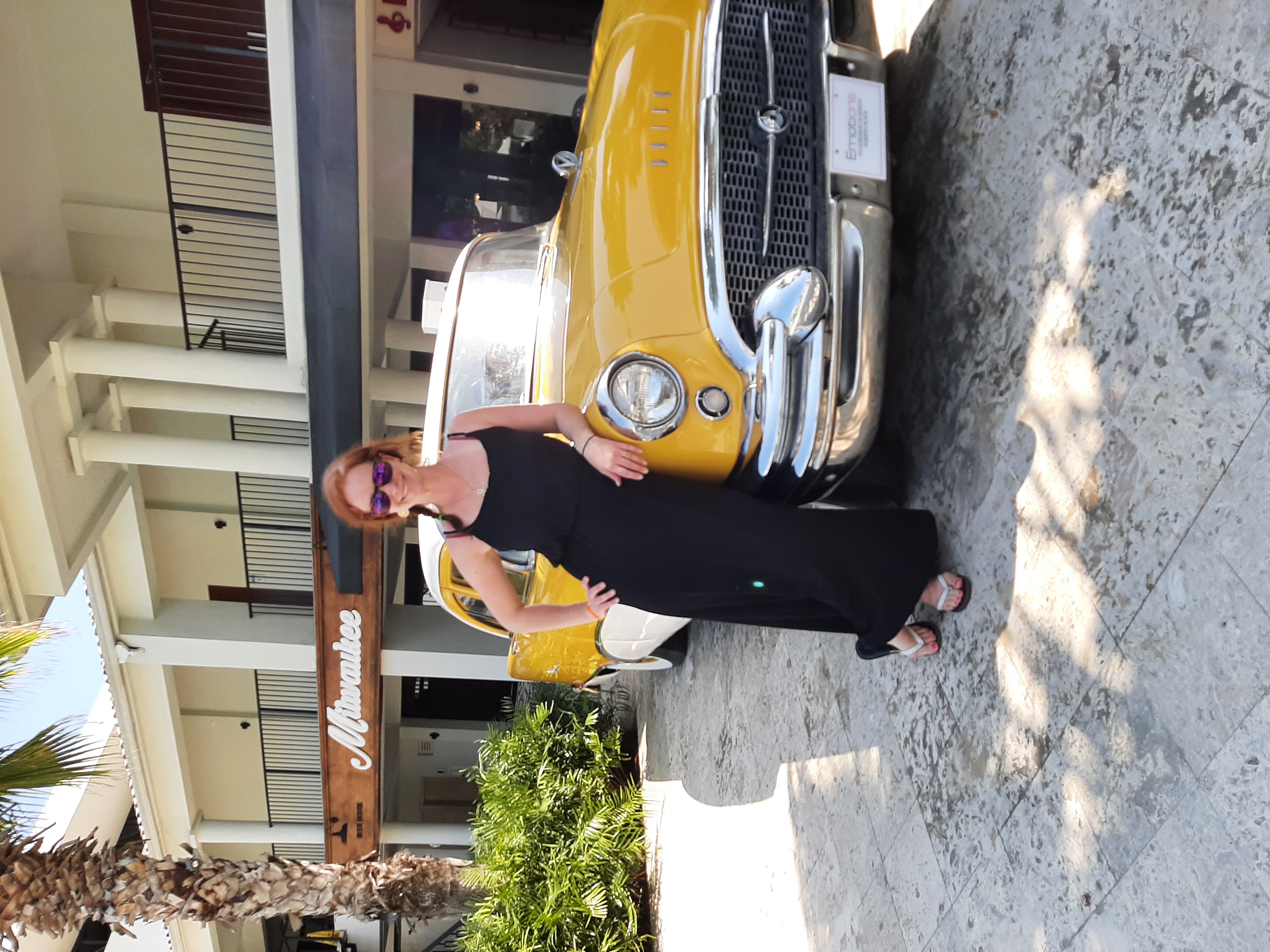 Femme devant une voiture ancienne jaune