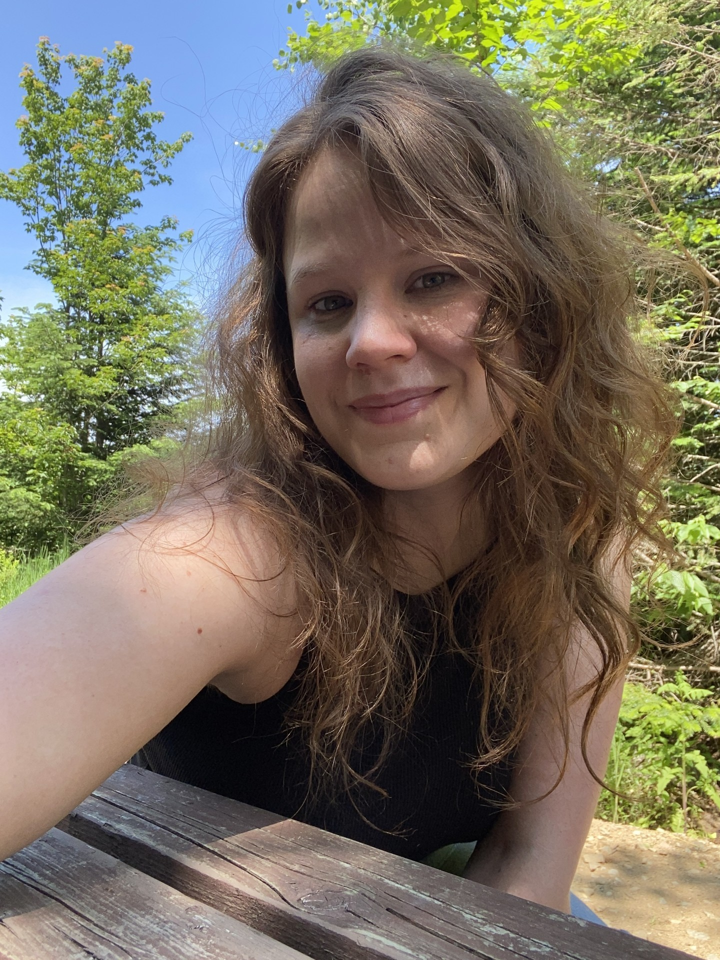 Selfie d'une jeune femme sur une table à pique nique