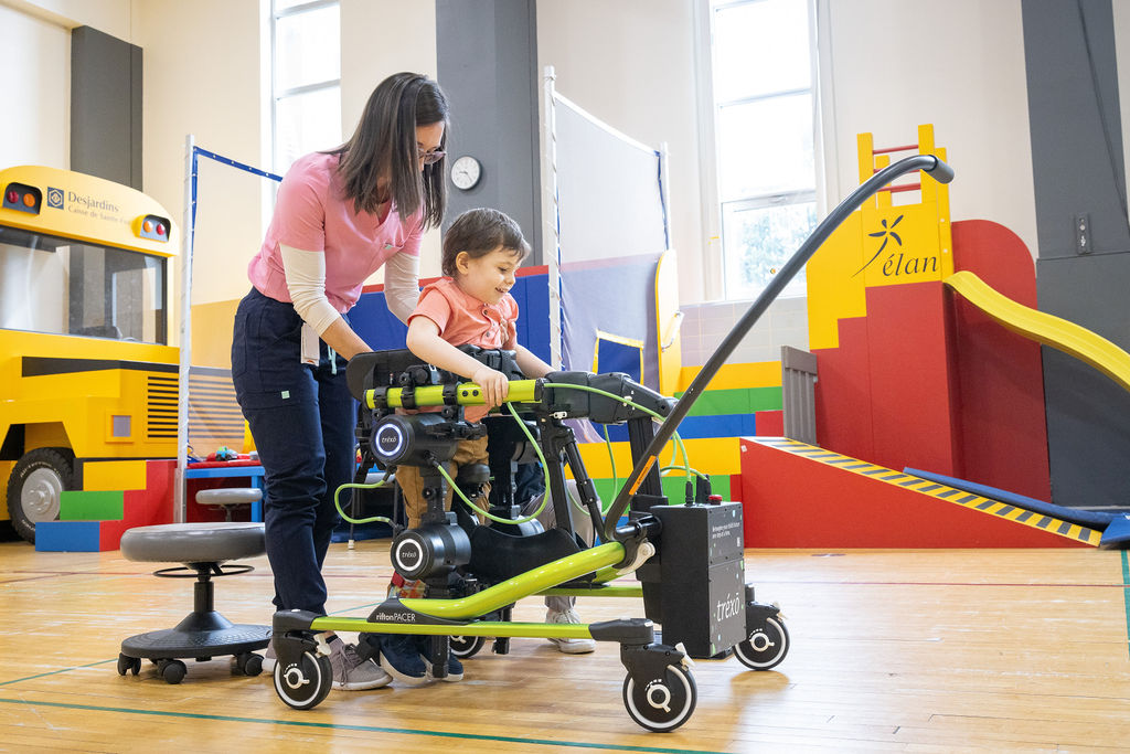 Intervenante avec enfant avec marchette exosquelette robotisée