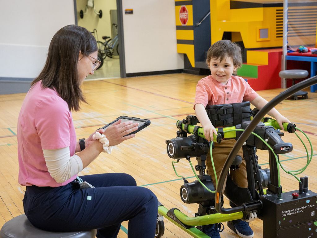 Intervenante avec enfant avec marchette exosquelette robotisée